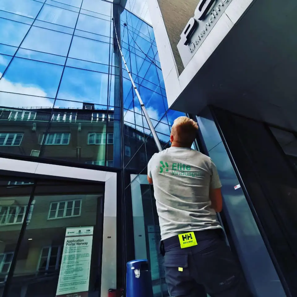 Ansatt i Elite Vinduspuss som pusser vinduer.